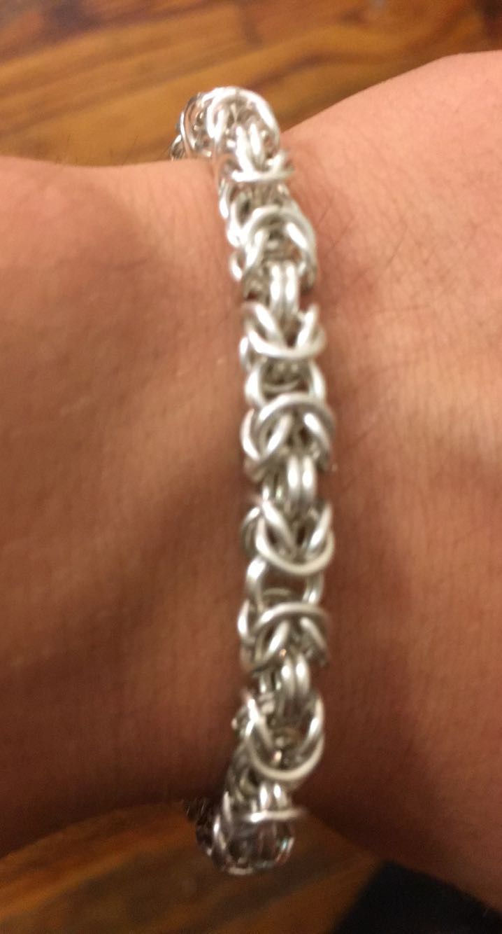 Handwoven silver-toned Byzantine chain bracelet worn on the wrist