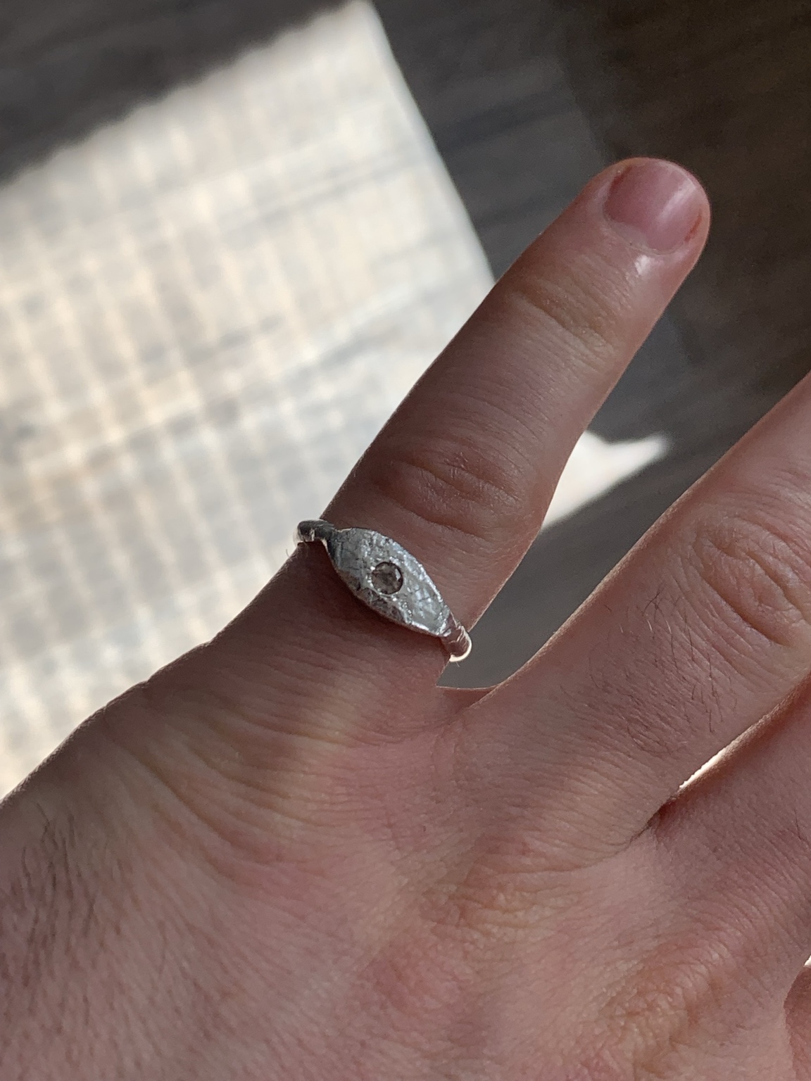Textured eye-shaped ring with a small central stone