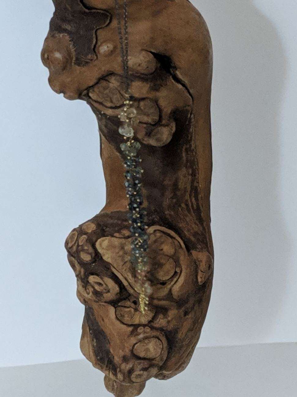 Pendant with a cluster of small stones displayed on wood
