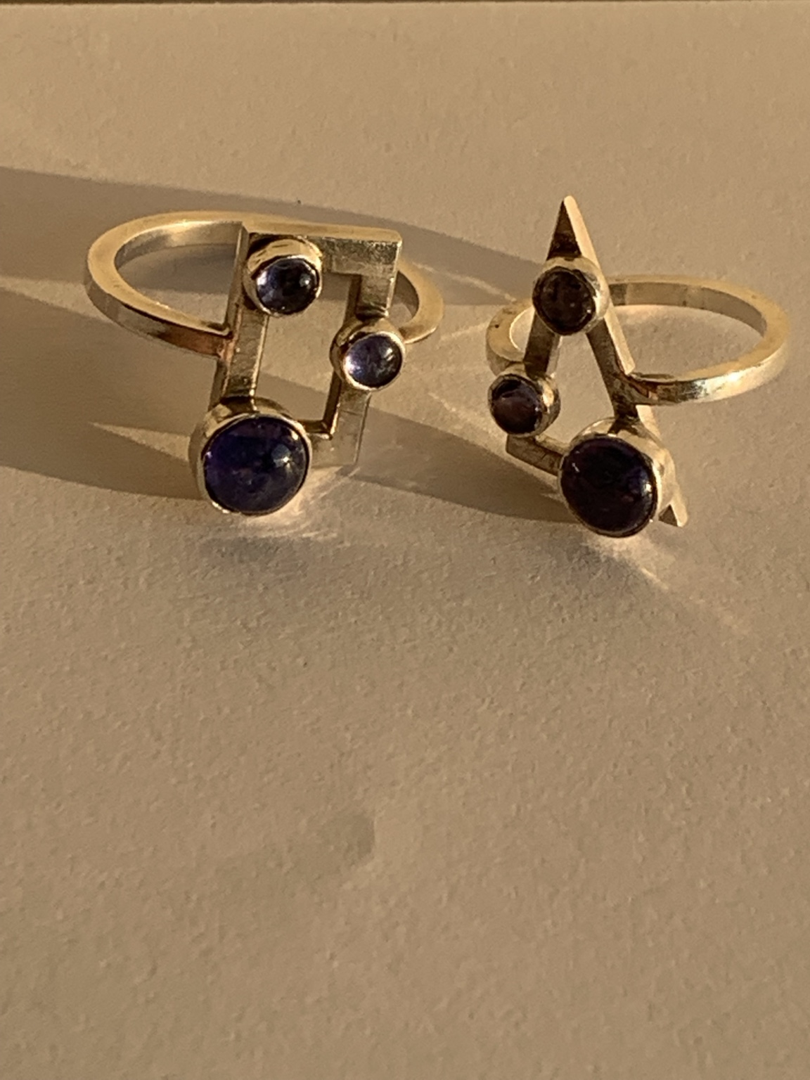 Geometric stone-set rings displayed upright