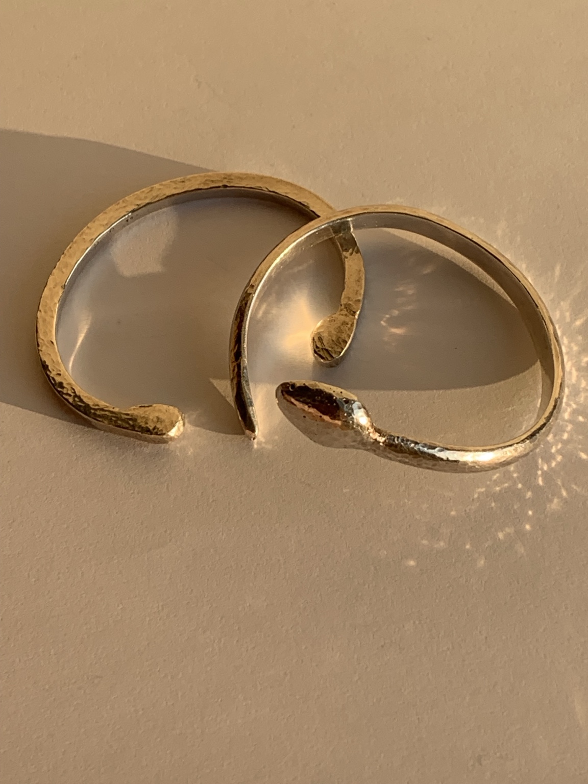 Two open-ended hand-forged bands in contrasting metal tones
