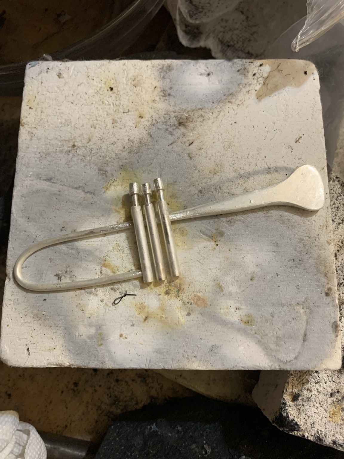 Trumpet cuff components arranged on a soldering block