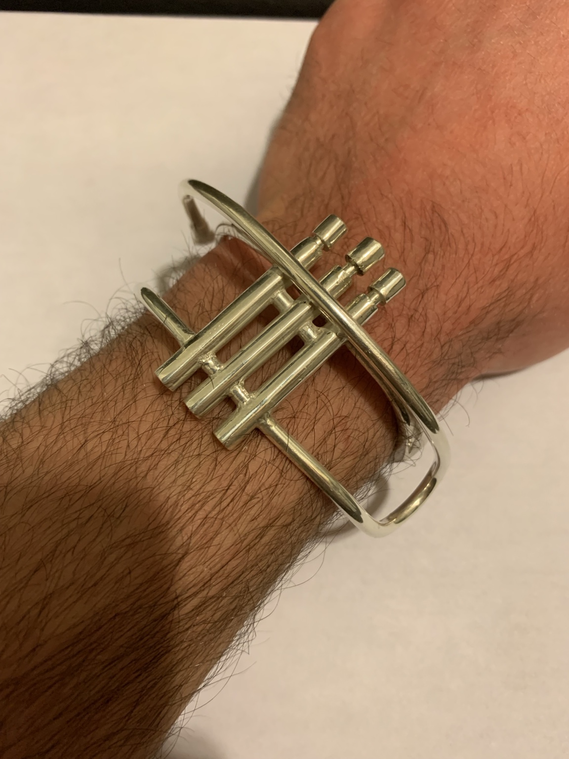 Sculptural trumpet cuff worn on the wrist